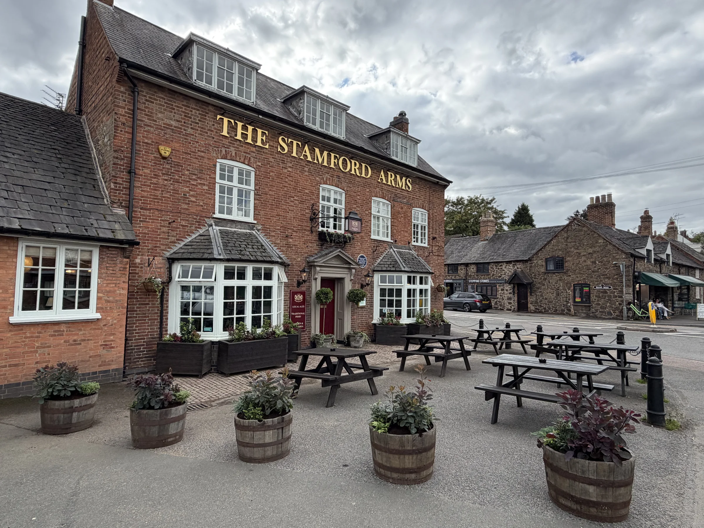 The Stamford Arms brick exterior with picnic tables and planters