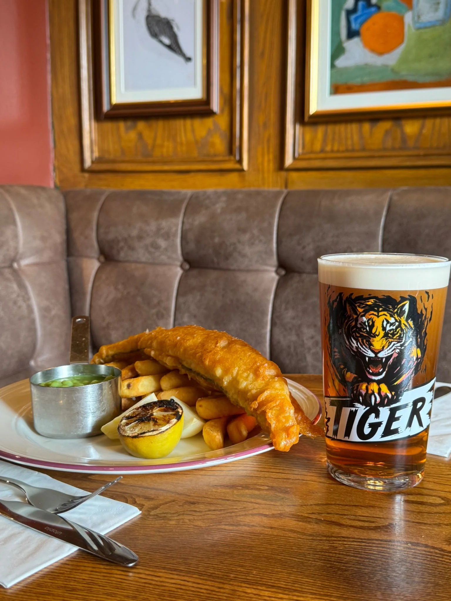 Battered fish and chips served beside a pint of Everards Tiger